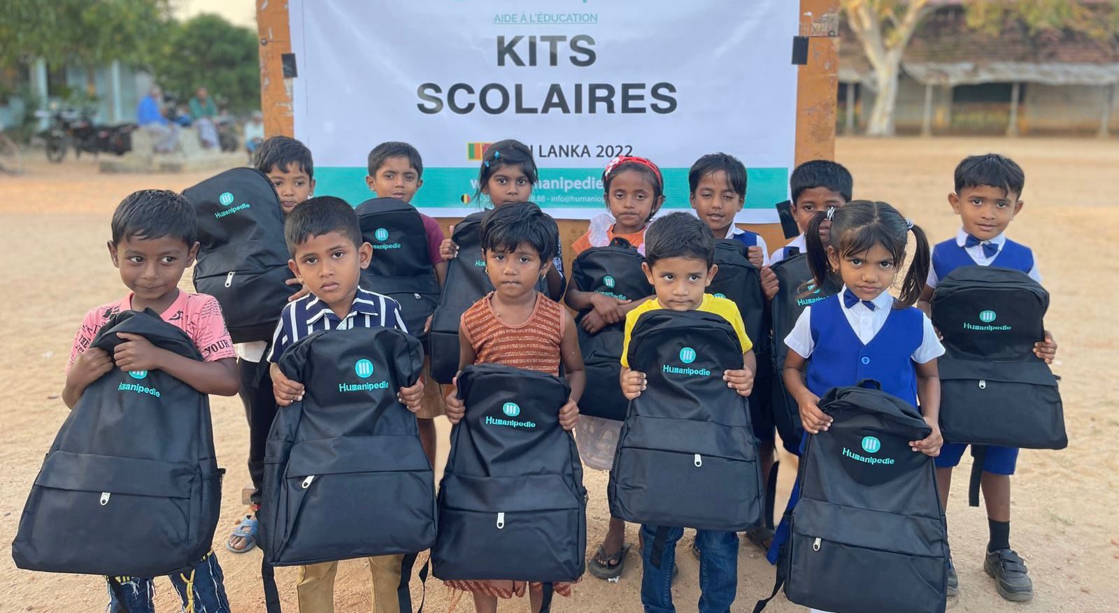 Children holding new school bags donated through an education programme